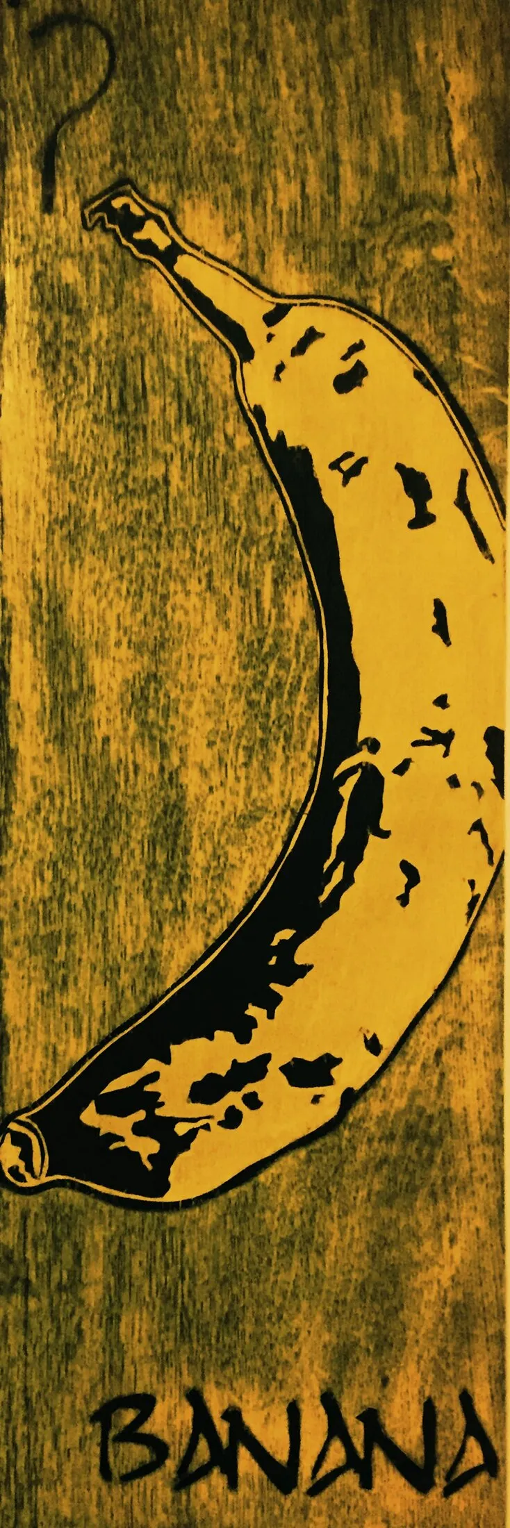 Pop-art style painting of a single curved banana on a wood-grain background, with a black question mark above it and the word BANANA painted in bold graffiti-style lettering below.