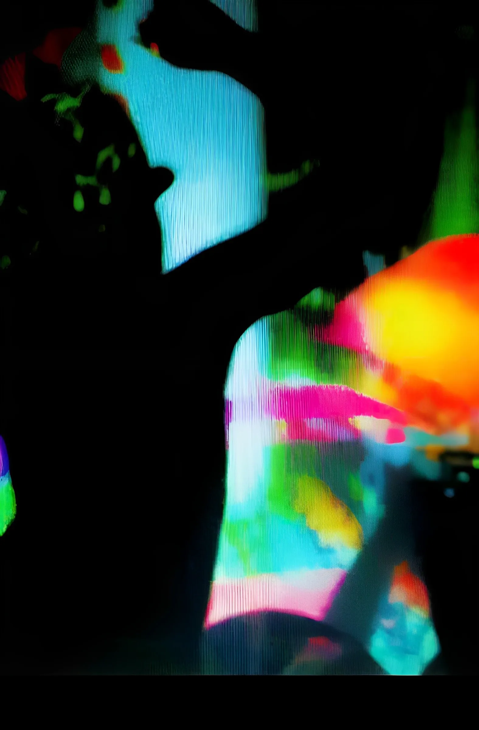 Abstract color photograph combining a dark silhouetted tree branch with blurred, vividly colored streaks of pink, orange, yellow, green, and blue light.